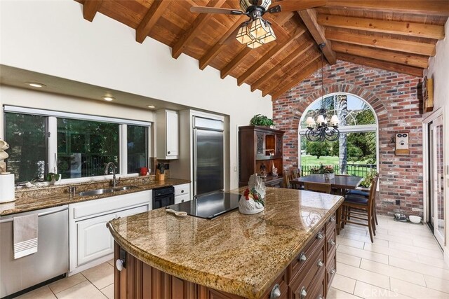 kitchen with a sink, lofted ceiling with beams, wood ceiling, light tile patterned floors, and dishwasher