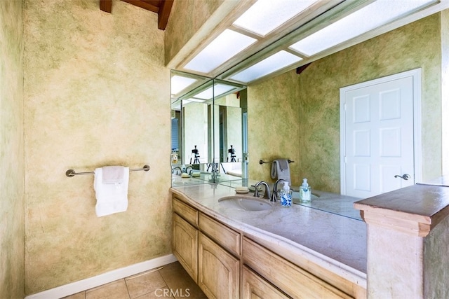 bathroom featuring baseboards, vanity, and tile patterned flooring