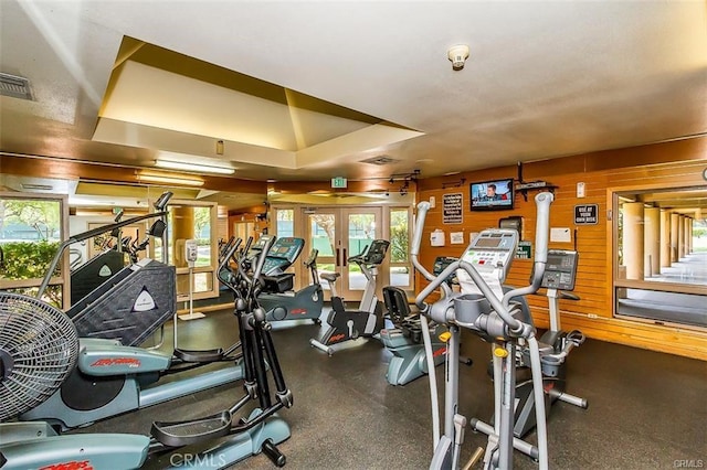 gym with french doors, visible vents, and wood walls