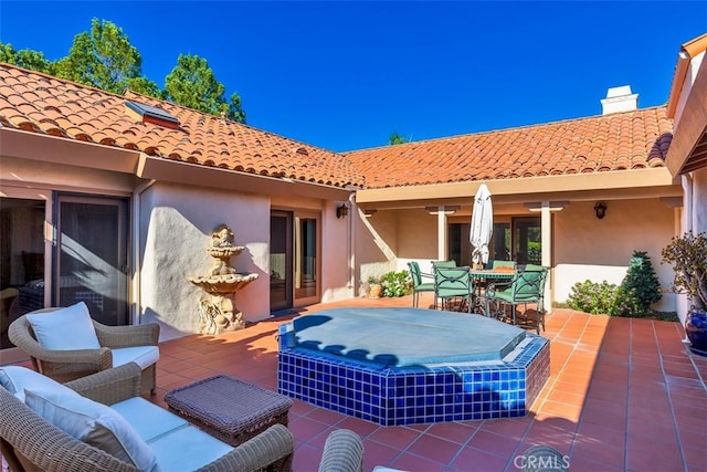 view of patio with an outdoor hot tub and outdoor dining space