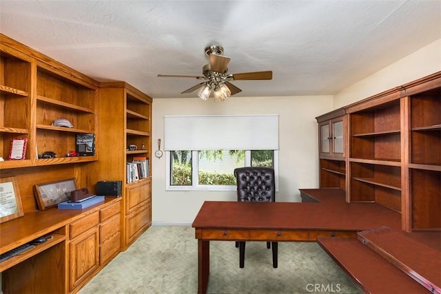 office featuring light carpet, a textured ceiling, and ceiling fan