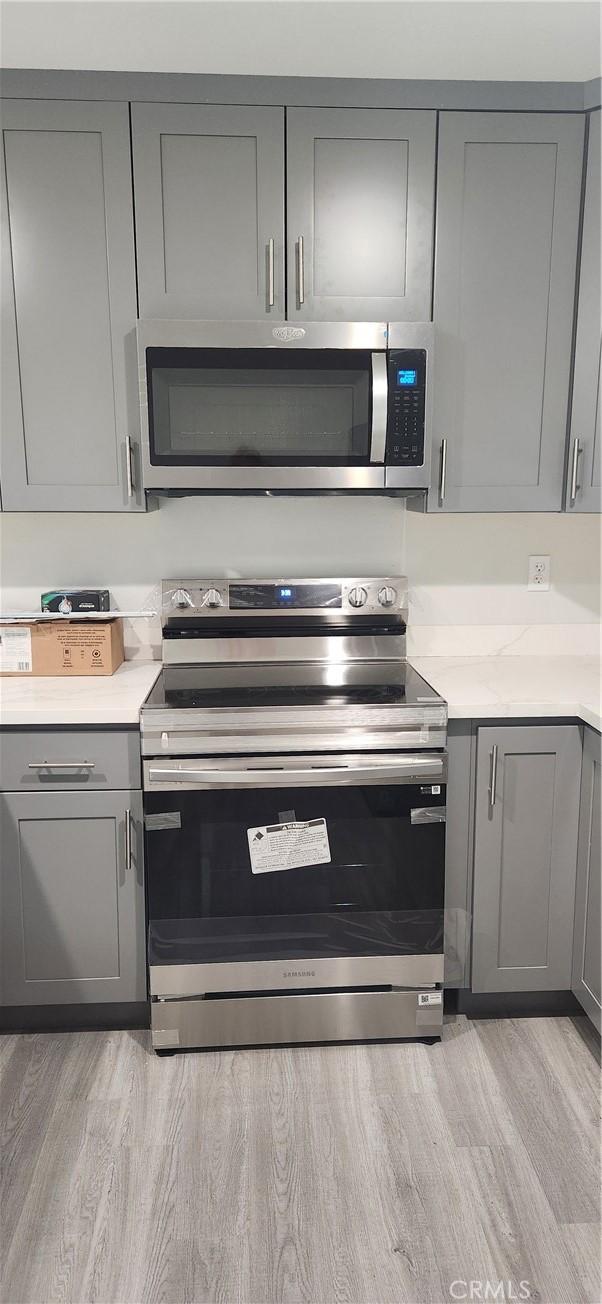 3590 Redwood St, Clearlake, CA 95422 - kitchen with appliances with stainless steel finishes, gray cabinets, light wood-style flooring, and light countertops