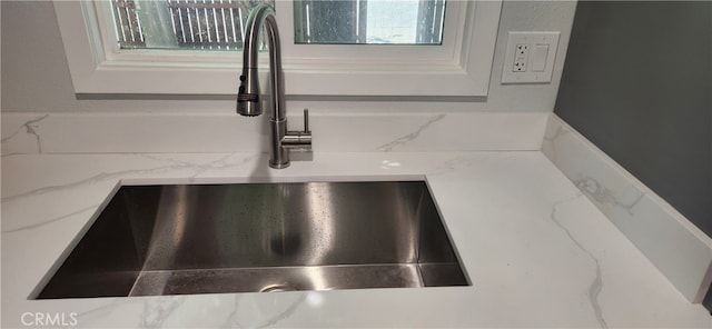 room details with light stone countertops and sink