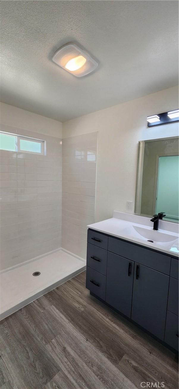 3590 Redwood St, Clearlake, CA 95422 - full bath featuring vanity, wood finished floors, tiled shower, and a textured ceiling