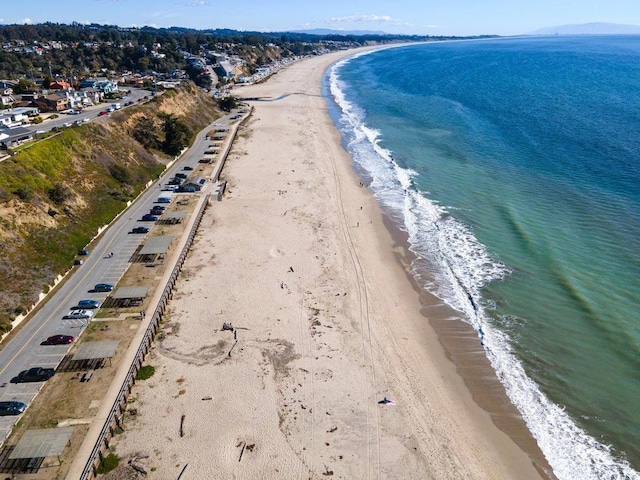 birds eye view of property with a water view and a beach view