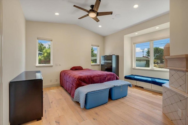 bedroom featuring light hardwood / wood-style floors, lofted ceiling, multiple windows, and ceiling fan