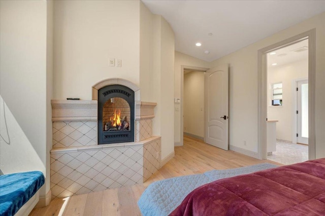 bedroom with light wood-type flooring and ensuite bath