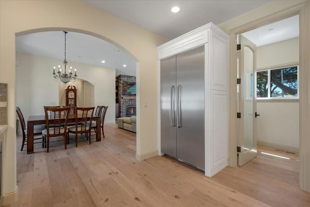 hallway featuring light hardwood / wood-style floors and an inviting chandelier