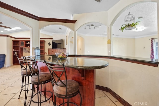 bar featuring light tile patterned floors, a textured ceiling, and ornamental molding