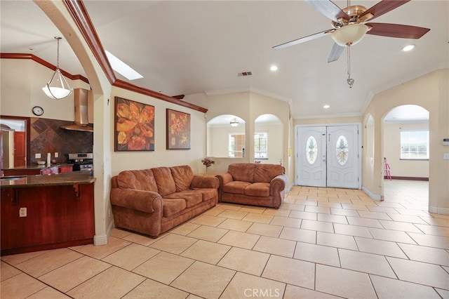 tiled living room with vaulted ceiling, ceiling fan, a healthy amount of sunlight, and crown molding