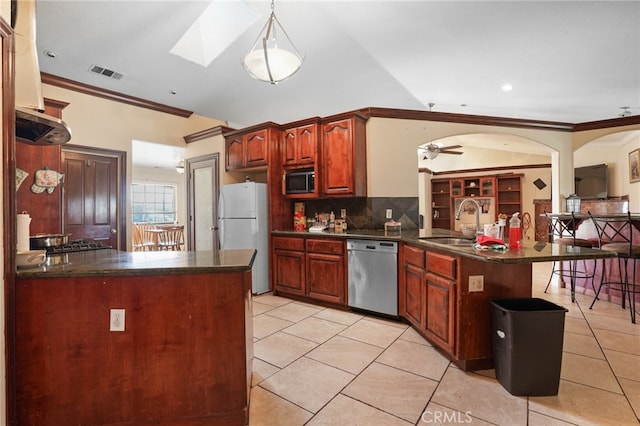 kitchen with appliances with stainless steel finishes, hanging light fixtures, ceiling fan, ornamental molding, and sink