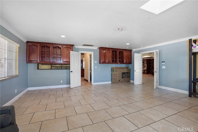 unfurnished living room featuring crown molding, light tile patterned floors, and a skylight