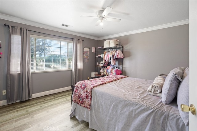 bedroom with ornamental molding, ceiling fan, and hardwood / wood-style flooring