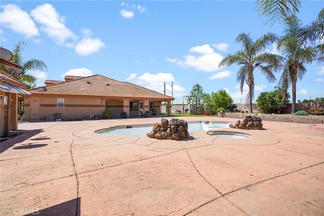 view of swimming pool featuring an in ground hot tub and a patio area