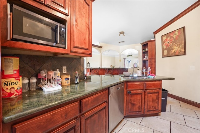 kitchen featuring light tile patterned floors, sink, tasteful backsplash, stainless steel appliances, and dark stone counters