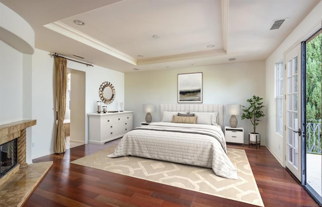 bedroom with french doors, a raised ceiling, and dark wood-type flooring