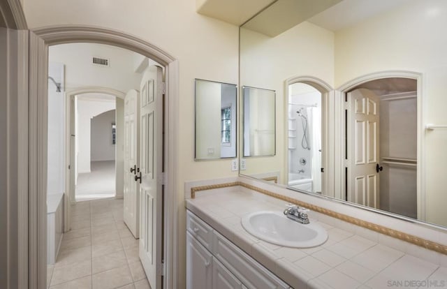 bathroom featuring vanity, tile patterned flooring, and shower / washtub combination