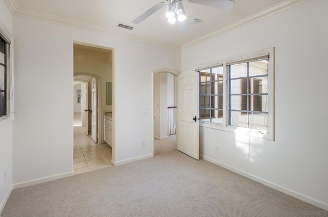 empty room with ceiling fan, light colored carpet, and ornamental molding