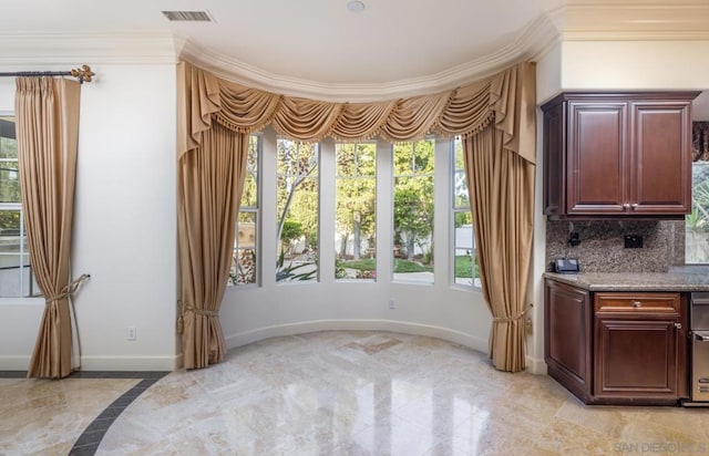 interior space with decorative backsplash, ornamental molding, and light stone counters