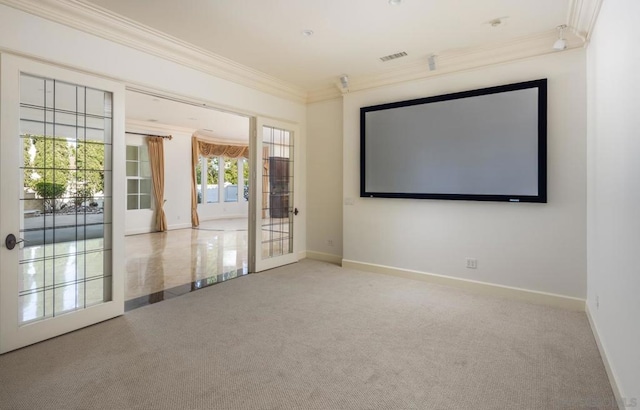 carpeted home theater with french doors and crown molding