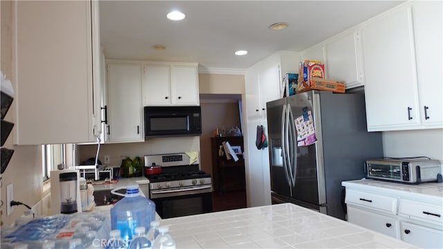 kitchen featuring ornamental molding, stainless steel appliances, white cabinets, and tile countertops