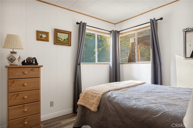 bedroom with wooden walls and dark hardwood / wood-style flooring