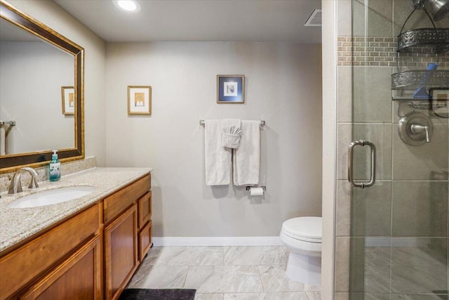 bathroom featuring a shower with door, toilet, and vanity