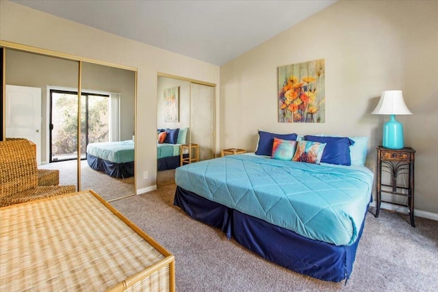 carpeted bedroom featuring multiple closets and lofted ceiling