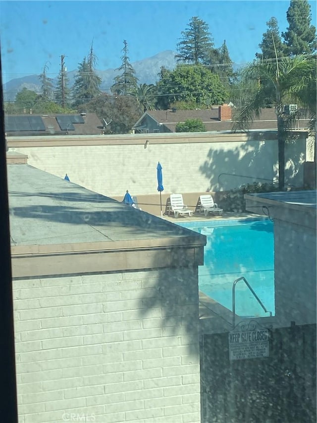 view of swimming pool with a mountain view