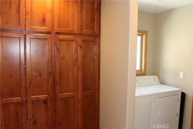 laundry room with washer and clothes dryer and cabinets