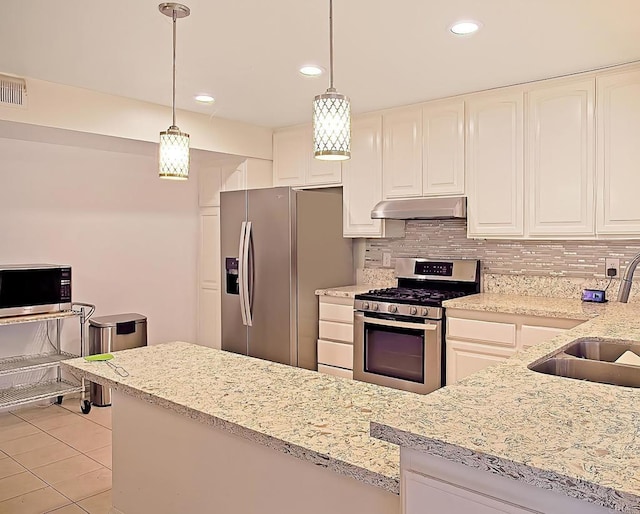 kitchen featuring decorative backsplash, decorative light fixtures, stainless steel appliances, and sink