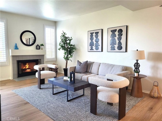 living room with a wealth of natural light, a fireplace, and light wood-type flooring