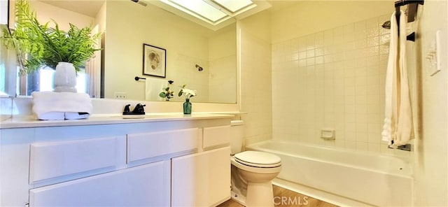 full bathroom with a skylight, tiled shower / bath combo, hardwood / wood-style floors, toilet, and vanity