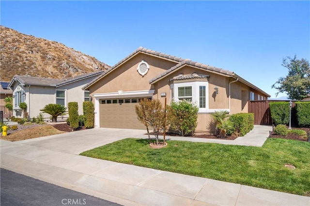 view of front of property with a mountain view, a garage, and a front lawn