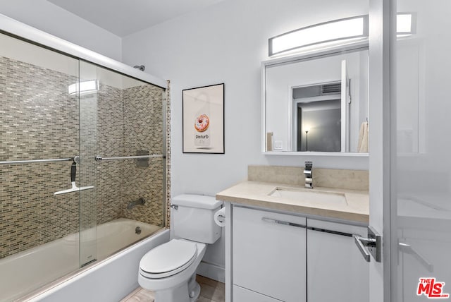 full bathroom with shower / bath combination with glass door, vanity, and toilet