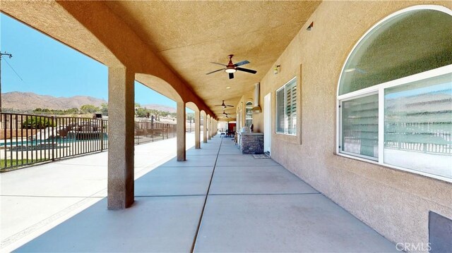 view of patio / terrace featuring ceiling fan and a mountain view