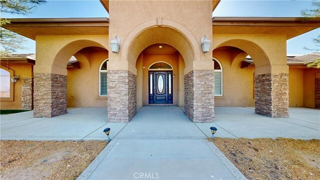 entrance to property with stucco siding and stone siding