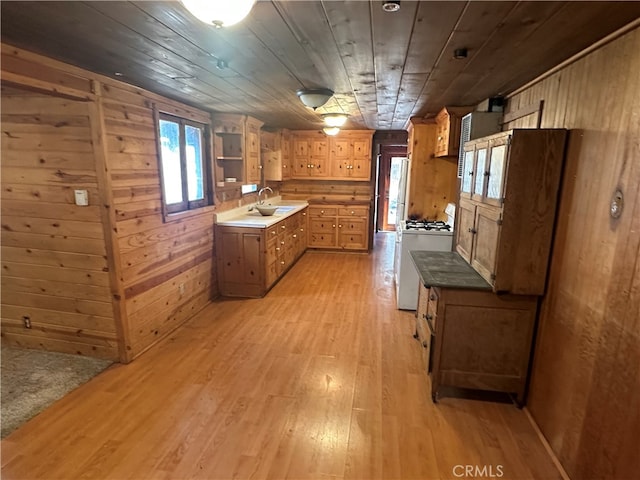 kitchen with wood ceiling, wooden walls, white gas range oven, and light wood-type flooring