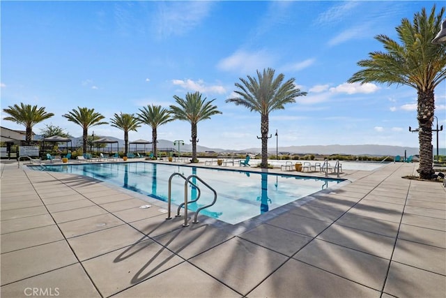 view of pool featuring a mountain view and a patio area