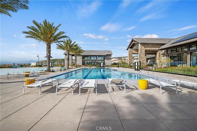 view of swimming pool featuring a patio area and a water view