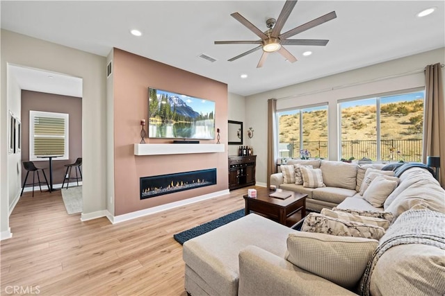 living room featuring light wood-type flooring and ceiling fan