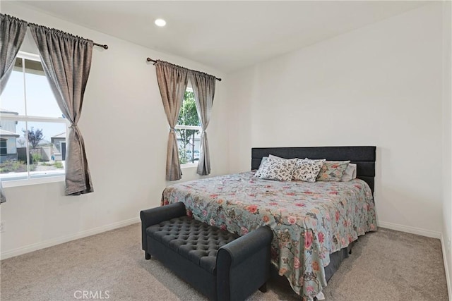 bedroom featuring multiple windows and light colored carpet