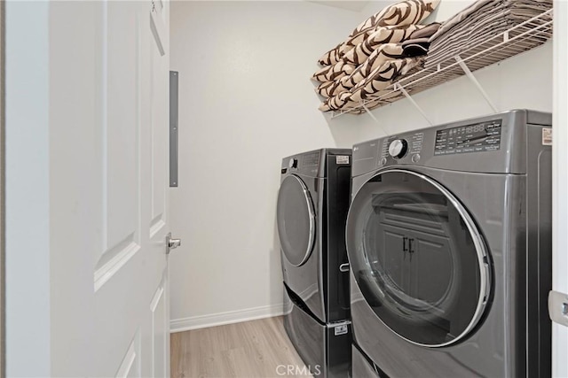 washroom with light wood-type flooring and washer and clothes dryer