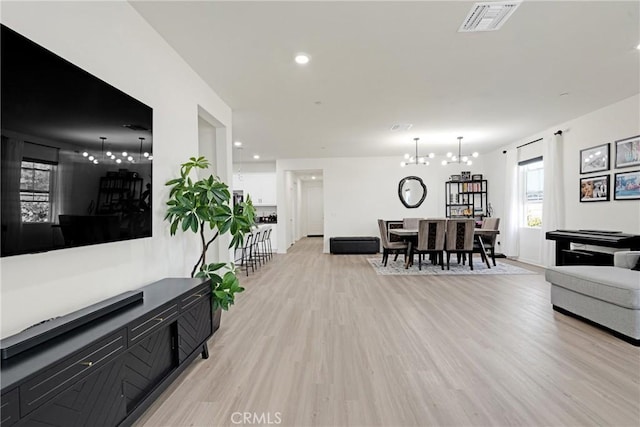 living room with a notable chandelier and light wood-type flooring