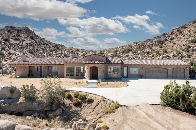 mediterranean / spanish-style house with a mountain view and a garage