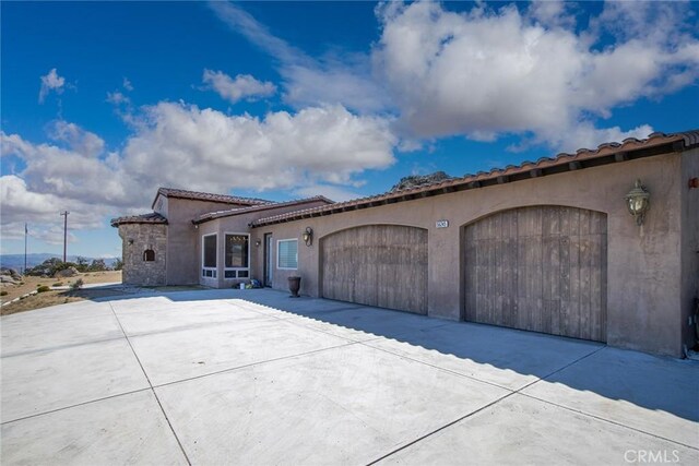 56245 Cobalt Rd, Yucca Valley, CA 92284 - view of front of property with concrete driveway, an attached garage, stucco siding, and a tiled roof