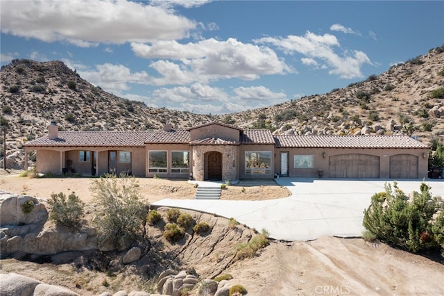 mediterranean / spanish home featuring a garage and a mountain view