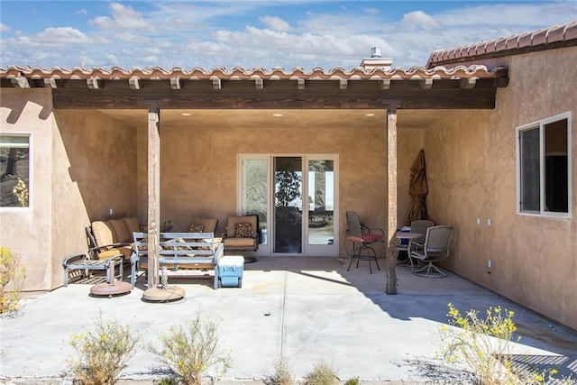 back of house featuring an outdoor hangout area, a patio, and stucco siding