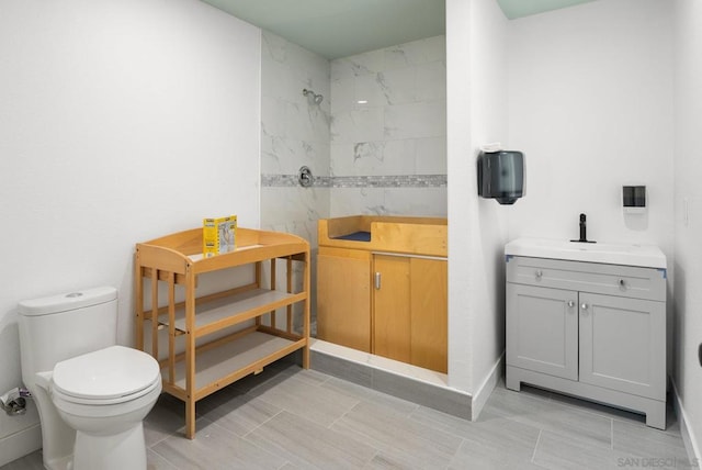 bathroom featuring vanity, toilet, and tiled shower