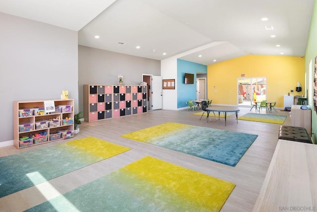 recreation room featuring wood-type flooring and lofted ceiling